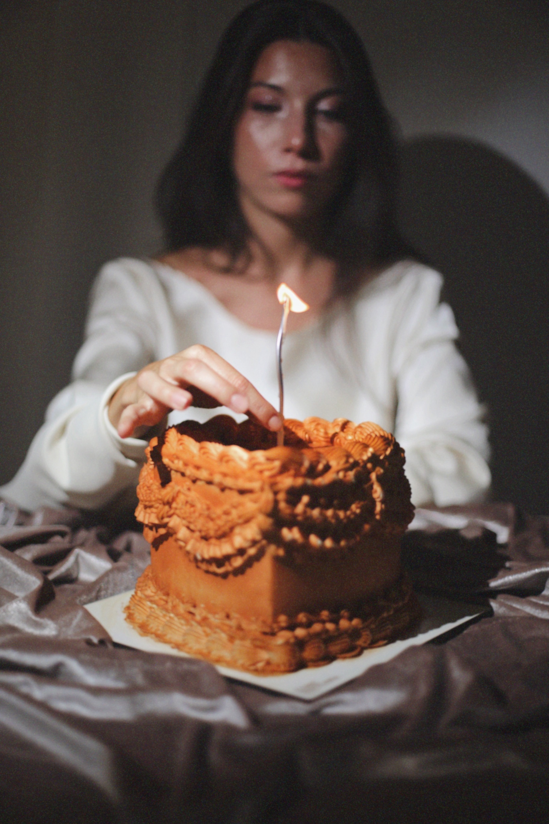 Mujer encendiendo la vela de una tarta corazón vintage de Iconic Pastelería