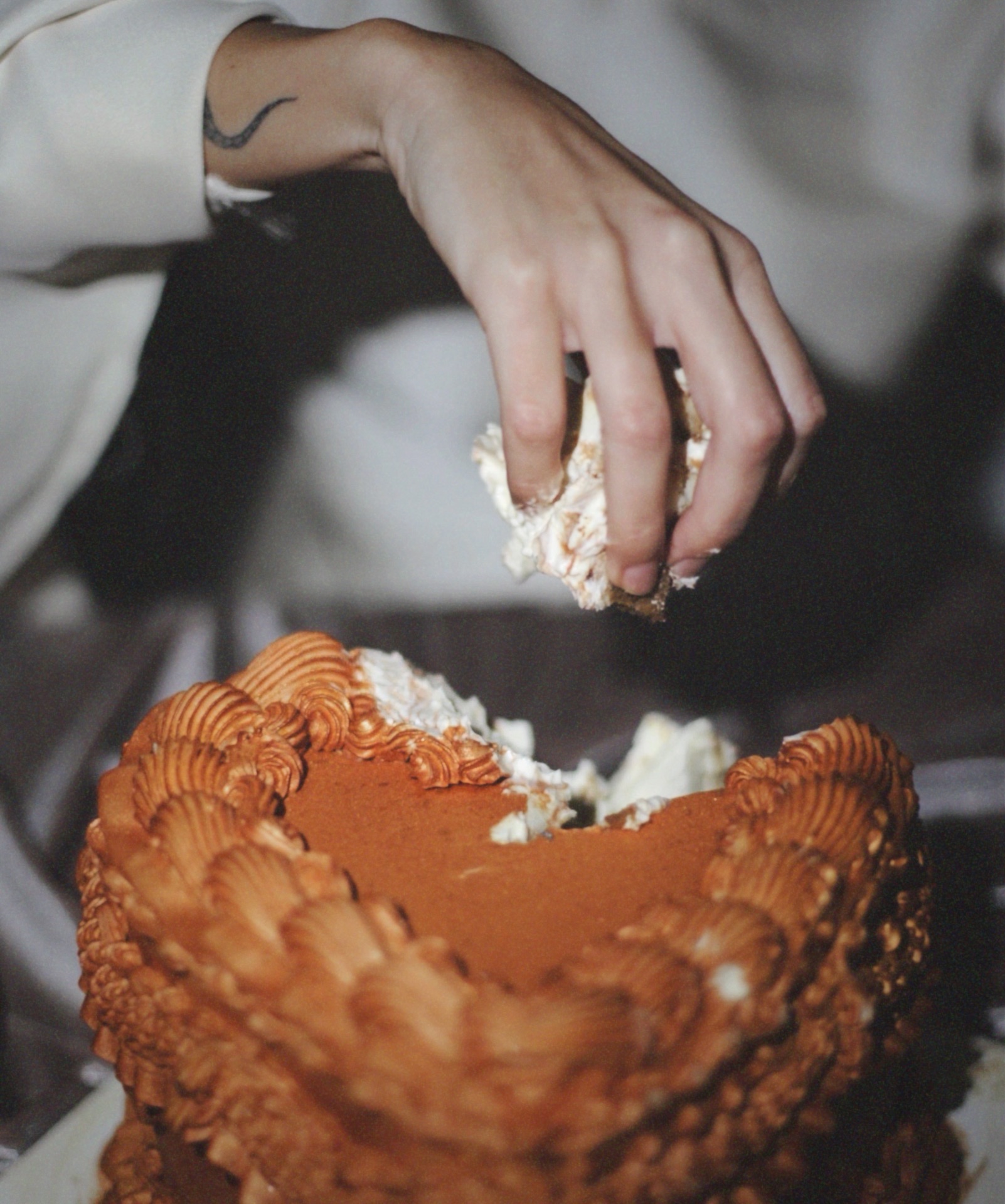 Mano tomando crema de una tarta corazón vintage color caramelo